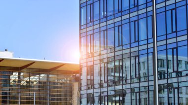 Çağdaş mimarinin soyut bir parçası, camdan ve betondan yapılmış duvarlar. Yansıtıcı camla kaplı modern bir binanın cam kaplamalı dış cephesinin soyut yakın çekimi..