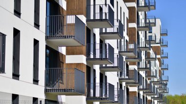  Mavi gökyüzü olan güneşli bir günde modern apartman binaları. Modern bir apartmanın ön cephesi. Gündüz gözüyle çağdaş yerleşim yerinin dış tarafında.. 