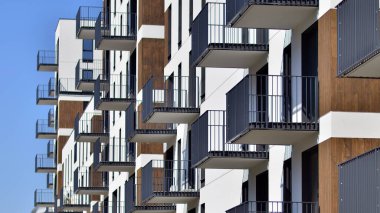  Mavi gökyüzü olan güneşli bir günde modern apartman binaları. Modern bir apartmanın ön cephesi. Gündüz gözüyle çağdaş yerleşim yerinin dış tarafında.. 