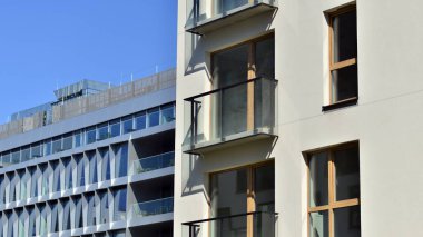 Mavi gökyüzü olan güneşli bir günde modern apartman binaları. Modern bir apartmanın ön cephesi. Gündüz gözüyle çağdaş yerleşim yerinin dış tarafında.. 