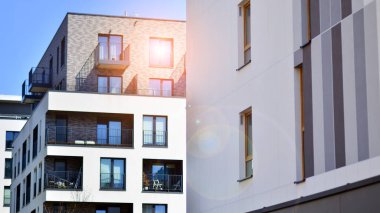 Mavi gökyüzü olan güneşli bir günde modern apartman binaları. Modern bir apartmanın ön cephesi. Gündüz gözüyle çağdaş yerleşim yerinin dış tarafında.. 