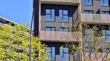 Ekoloji ve yeşil yaşam şehirde, kentsel çevre kavramı. Modern apartman ve yeşil ağaçlar. Ekolojik konut mimarisi. Ağaçların yakınında modern bir yerleşim yeri..