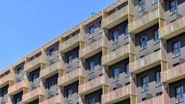 Mavi gökyüzü olan güneşli bir günde modern apartman binaları. Modern bir apartmanın ön cephesi. Gündüz gözüyle çağdaş yerleşim yerinin dış tarafında.. 