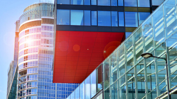Windows of a modern glass building. Looking up at the commercial buildings in downtown. Modern office building against blue sky.