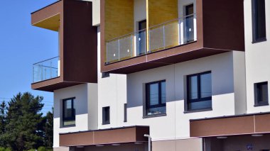 Mavi gökyüzü olan güneşli bir günde modern apartman binaları. Modern bir apartmanın ön cephesi. Gündüz gözüyle çağdaş yerleşim yerinin dış tarafında.. 
