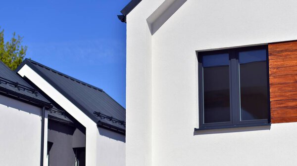 Terraced family homes in newly developed housing estate. The real estate market in the suburbs. New single family houses in a new development area. Residential homes with modern facade. 