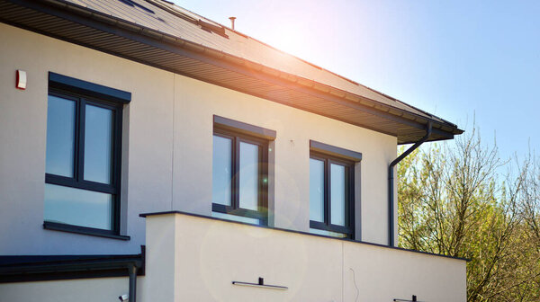 Terraced family homes in newly developed housing estate. The real estate market in the suburbs. New single family houses in a new development area. Residential homes with modern facade. 