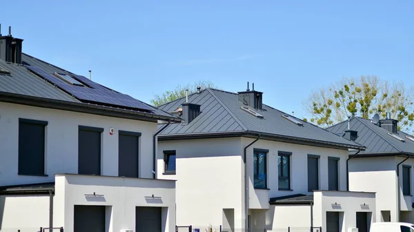 stock image Terraced family homes in newly developed housing estate. The real estate market in the suburbs. New single family houses in a new development area. Residential homes with modern facade. 