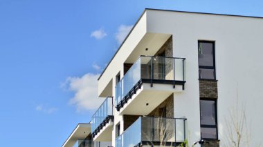 Mavi gökyüzü olan güneşli bir günde modern apartman binaları. Modern bir apartmanın ön cephesi. Gündüz gözüyle çağdaş yerleşim yerinin dış tarafında.. 