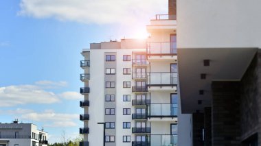  Mavi gökyüzü olan güneşli bir günde modern apartman binaları. Modern bir apartmanın ön cephesi. Gündüz gözüyle çağdaş yerleşim yerinin dış tarafında.. 