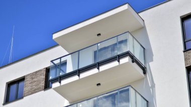  Mavi gökyüzü olan güneşli bir günde modern apartman binaları. Modern bir apartmanın ön cephesi. Gündüz gözüyle çağdaş yerleşim yerinin dış tarafında.. 
