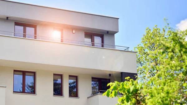 stock image Ecology and green living in city, urban environment concept. Modern apartment building and green trees. Ecological housing architecture. A modern residential building in the vicinity of trees.