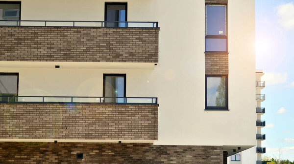  Современные жилые дома в солнечный день с голубым небом. Фасад современного многоквартирного дома. Внешний вид современного жилого здания при дневном свете. 