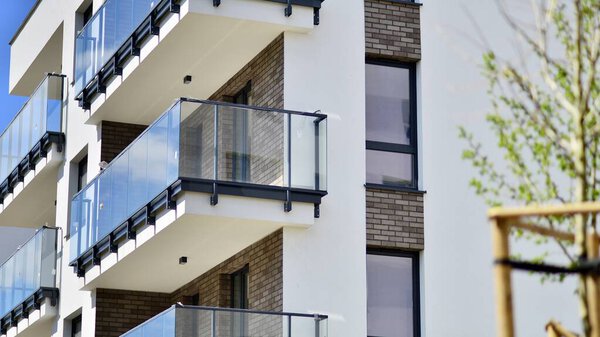 Экология и зеленая жизнь в городе, концепция городской среды. Современный жилой дом и зеленые деревья. Экологическая жилищная архитектура. Современное жилое здание в окрестностях деревьев.