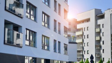 Parlak yüzlü apartman dairesi. Bir sürü kare cam pencere ve balkonu olan modern minimalist mimari.