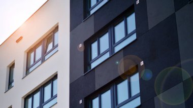 Parlak yüzlü apartman dairesi. Bir sürü kare cam pencere ve balkonu olan modern minimalist mimari.