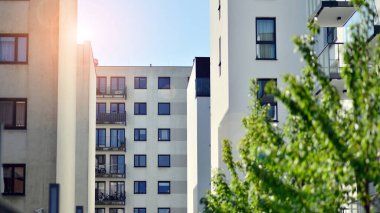 Parlak yüzlü apartman dairesi. Bir sürü kare cam pencere ve balkonu olan modern minimalist mimari.