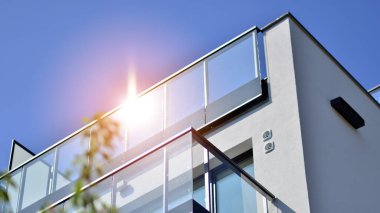 Parlak yüzlü apartman dairesi. Bir sürü kare cam pencere ve balkonu olan modern minimalist mimari.