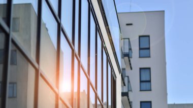 Parlak yüzlü apartman dairesi. Bir sürü kare cam pencere ve balkonu olan modern minimalist mimari.