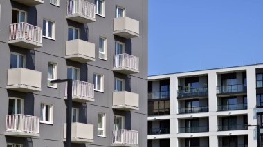 Parlak yüzlü apartman dairesi. Bir sürü kare cam pencere ve balkonu olan modern minimalist mimari.