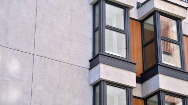 Parlak yüzlü apartman dairesi. Bir sürü kare cam pencere ve balkonu olan modern minimalist mimari.