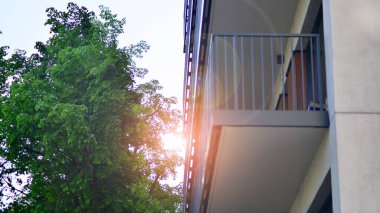 Çevre mimarisi. Yeşil ağaç ve yeni apartman. Doğanın ve modernliğin ahengi. Yeşil yerleşim bölgesinde yeni daireleri olan modern bir yerleşim yeri.. 