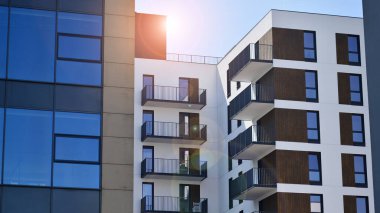 Parlak yüzlü apartman dairesi. Bir sürü kare cam pencere ve balkonu olan modern minimalist mimari.