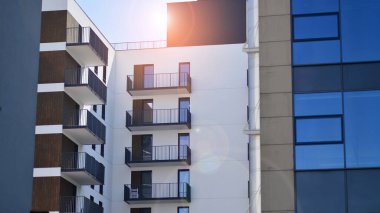 Parlak yüzlü apartman dairesi. Bir sürü kare cam pencere ve balkonu olan modern minimalist mimari.