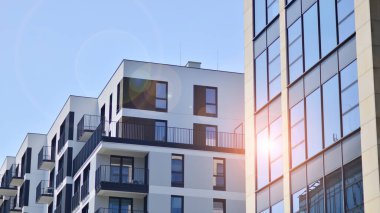 Parlak yüzlü apartman dairesi. Bir sürü kare cam pencere ve balkonu olan modern minimalist mimari.
