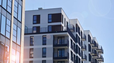 Çevre mimarisi. Yeşil ağaç ve yeni apartman. Doğanın ve modernliğin ahengi. Yeşil yerleşim bölgesinde yeni daireleri olan modern bir yerleşim yeri.. 