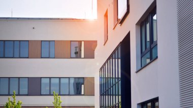 Parlak yüzlü apartman dairesi. Bir sürü kare cam pencere ve balkonu olan modern minimalist mimari.