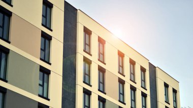 Parlak yüzlü apartman dairesi. Bir sürü kare cam pencere ve balkonu olan modern minimalist mimari.