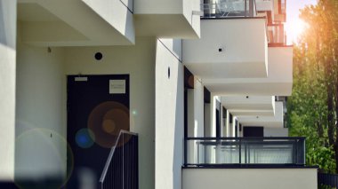 Çevre mimarisi. Yeşil ağaç ve yeni apartman. Doğanın ve modernliğin ahengi. Yeşil yerleşim bölgesinde yeni daireleri olan modern bir yerleşim yeri.. 