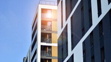 Parlak yüzlü apartman dairesi. Bir sürü kare cam pencere ve balkonu olan modern minimalist mimari.