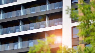 Çevre mimarisi. Yeşil ağaç ve yeni apartman. Doğanın ve modernliğin ahengi. Yeşil yerleşim bölgesinde yeni daireleri olan modern bir yerleşim yeri.. 