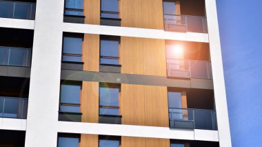 Parlak yüzlü apartman dairesi. Bir sürü kare cam pencere ve balkonu olan modern minimalist mimari.