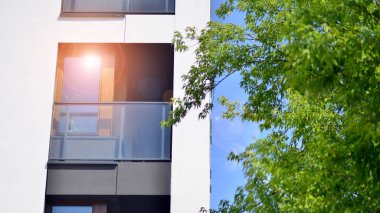 Çevre mimarisi. Yeşil ağaç ve yeni apartman. Doğanın ve modernliğin ahengi. Yeşil yerleşim bölgesinde yeni daireleri olan modern bir yerleşim yeri.. 