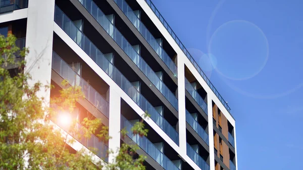 stock image Eco architecture. Green tree and new apartment building. The harmony of nature and modernity. Modern residential building with new apartments in a green residential area. 