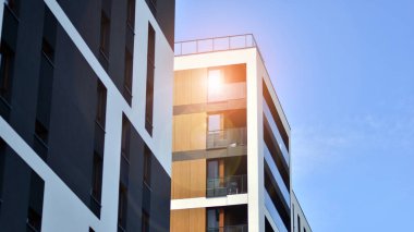 Parlak yüzlü apartman dairesi. Bir sürü kare cam pencere ve balkonu olan modern minimalist mimari.