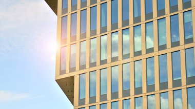 Yansıtıcı camlarla kaplı modern bir binanın cam kaplamalı dış cephesinin soyut yakın çekimi. Mimari soyut arkaplan. Cam duvar ve ön cephe ayrıntıları.
