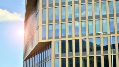 Yansıtıcı camlarla kaplı modern bir binanın cam kaplamalı dış cephesinin soyut yakın çekimi. Mimari soyut arkaplan. Cam duvar ve ön cephe ayrıntıları.