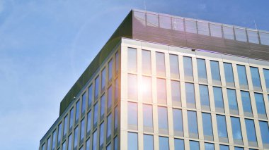 Yansıtıcı camlarla kaplı modern bir binanın cam kaplamalı dış cephesinin soyut yakın çekimi. Mimari soyut arkaplan. Cam duvar ve ön cephe ayrıntıları.