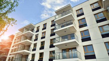 Çevre mimarisi. Yeşil ağaç ve yeni apartman. Doğanın ve modernliğin ahengi. Yeşil yerleşim bölgesinde yeni daireleri olan modern bir yerleşim yeri.. 