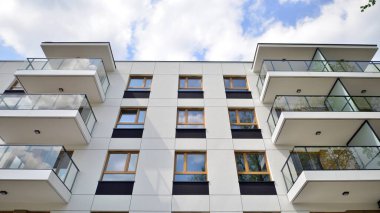 Çevre mimarisi. Yeşil ağaç ve yeni apartman. Doğanın ve modernliğin ahengi. Yeşil yerleşim bölgesinde yeni daireleri olan modern bir yerleşim yeri.. 