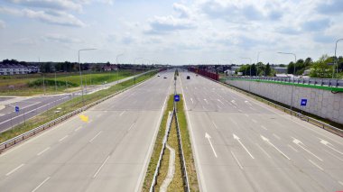 Mavi bulutlu bir günde yol sistemi. Beton bir otoyola bak. Beton üzerinde modern otoyol güvenlik işaretleri.