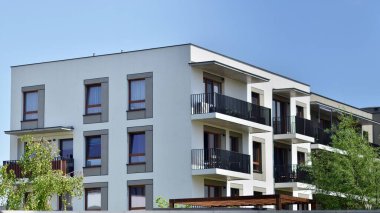 Çevre mimarisi. Yeşil ağaç ve yeni apartman. Doğanın ve modernliğin ahengi. Yeşil yerleşim bölgesinde yeni daireleri olan modern bir yerleşim yeri.. 