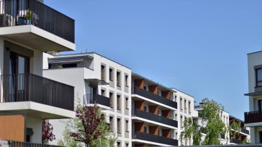 Çevre mimarisi. Yeşil ağaç ve yeni apartman. Doğanın ve modernliğin ahengi. Yeşil yerleşim bölgesinde yeni daireleri olan modern bir yerleşim yeri.. 