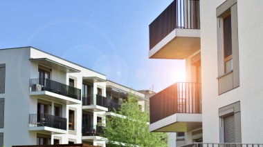 Çevre mimarisi. Yeşil ağaç ve yeni apartman. Doğanın ve modernliğin ahengi. Yeşil yerleşim bölgesinde yeni daireleri olan modern bir yerleşim yeri.. 