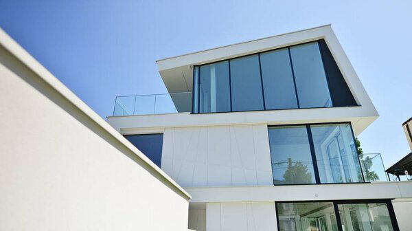 Elegant white house with open concept. Modern luxury villa exterior. A modern house with large windows and glazing.