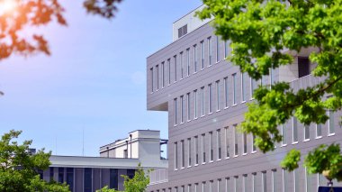 Çevre mimarisi. Binadaki ön cam ve alüminyum panellerin detayları. Yeşil ağaç ve modern ofis binası. Doğanın ve modernliğin ahengi. 